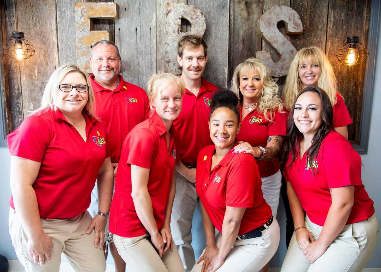 Executive Building Solutions employees in red company polos posing for group photo